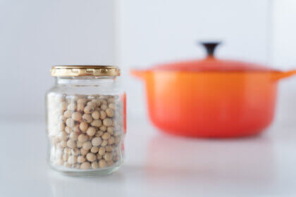 ビンに入れた乾燥大豆とルクルーゼのオレンジ色の鍋
