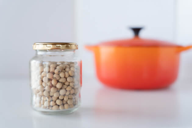 ビンに入れた乾燥大豆とルクルーゼのオレンジ色の鍋