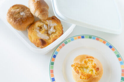 3つのパンがタッパーに入っていて、ひとつのパンがお皿にのっているところ