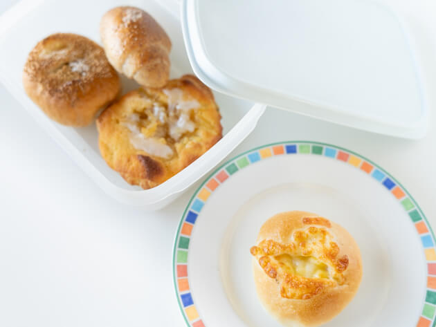 3つのパンがタッパーに入っていて、ひとつのパンがお皿にのっているところ